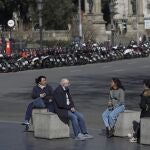 Unas personas descansan y hablan en el centro de Barcelona (Cataluña)