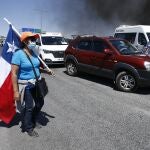 Vehículos detenidos por una barricada puesta por manifestantes durante protestas este sábado en Iquique, Chile