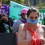 Miembros de un grupo a favor del aborto, protestan hoy jueves frente la Asamblea Nacional en Quito (Ecuador)
