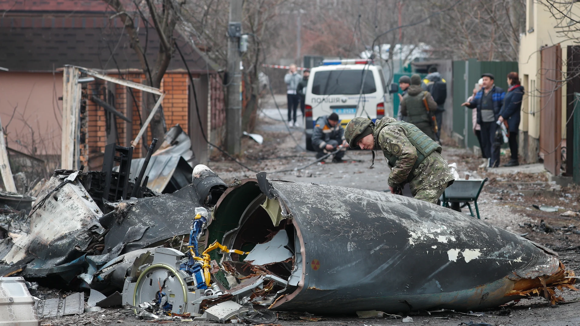 Kiev (Ucrania), 25/02/2022.- Un soldado observa los restos de un avión militar derribado durante la noche del 25 de febrero de 2022 en Kiev, Ucrania. Las tropas rusas entraron en Ucrania el 24 de febrero, lo que llevó al presidente del país a declarar la ley marcial. EFE/SERGEY DOLZHENKO