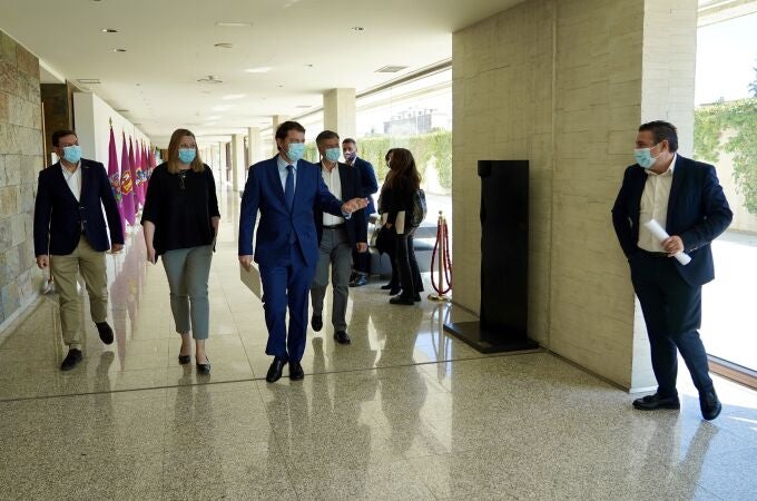 El candidato del PP a la Junta, Alfonso Fernández Mañueco, saluda al procurador electo por la UPL, Luis Mariano Santos, a su llegada a la reunión junto a Fernández Carriedo, Francisco Vázquez e Isabel Blanco