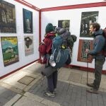 Dos peregrinos se detienen a contemplar la exposición ‘Carteles para un Camino, 100 años de Ilustración Jacobea’ en León