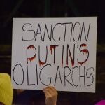 Un manifestante sostiene una pancarta "Sancionar a los oligarcas de Putin". Manifestantes reunidos frente a la embajada rusa en Londres en protesta por la invasión rusa de Ucrania. 05/03/2022