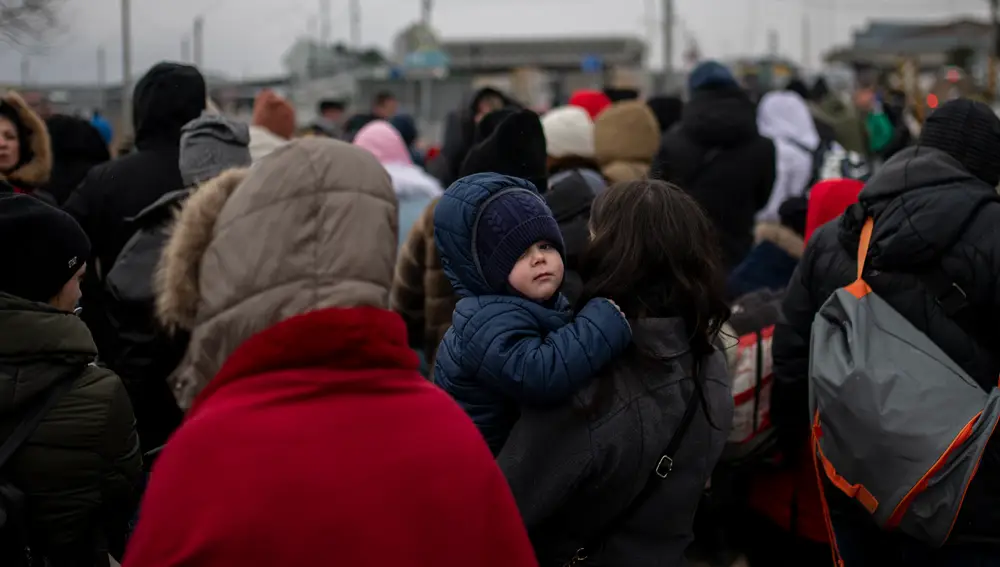 Varias personas esperando para cruzar a Rumanía, en el paso fronterizo de Porubne, en el oeste de Ucrania