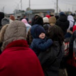 Varias personas esperando para cruzar a Rumanía, en el paso fronterizo de Porubne, en el oeste de Ucrania
