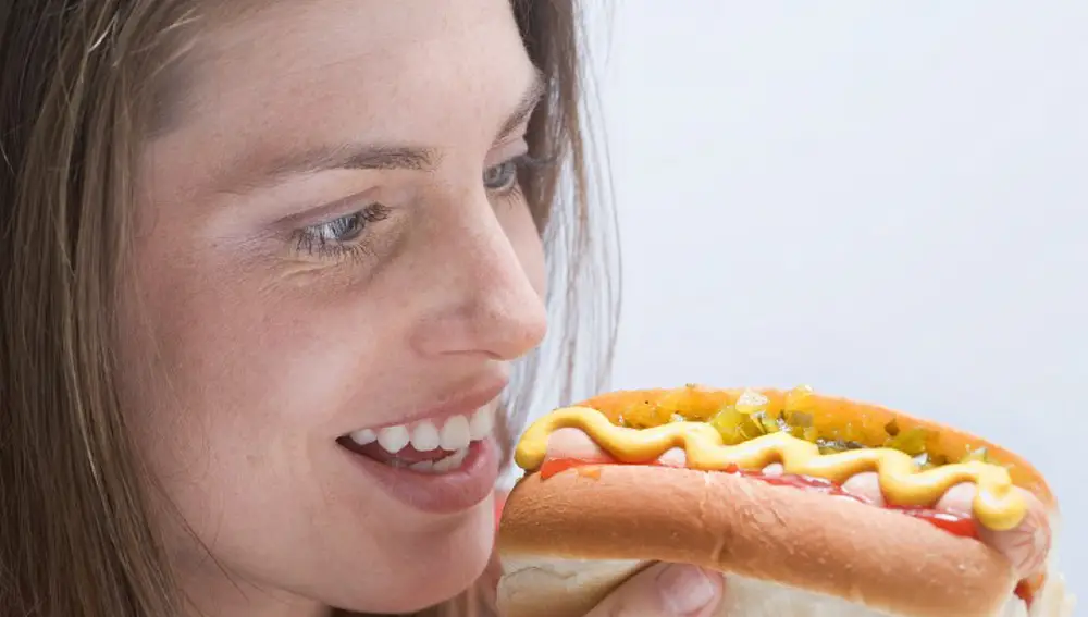 Mujer mirando un perrito caliente