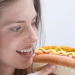 Mujer mirando un perrito caliente