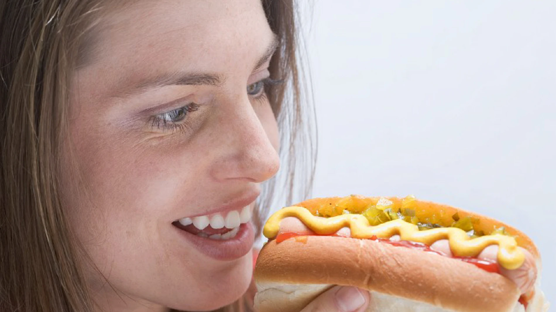Mujer mirando un perrito caliente