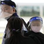 Una familia espera un taxi después de salir del Hospital Queen Elizabeth en Hong Kong