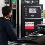 Un hombre repostando en una gasolinera en Getafe en la que numerosos coches hacen cola ante la subida de precios del combustible | Fuente: Jesús G.Feria