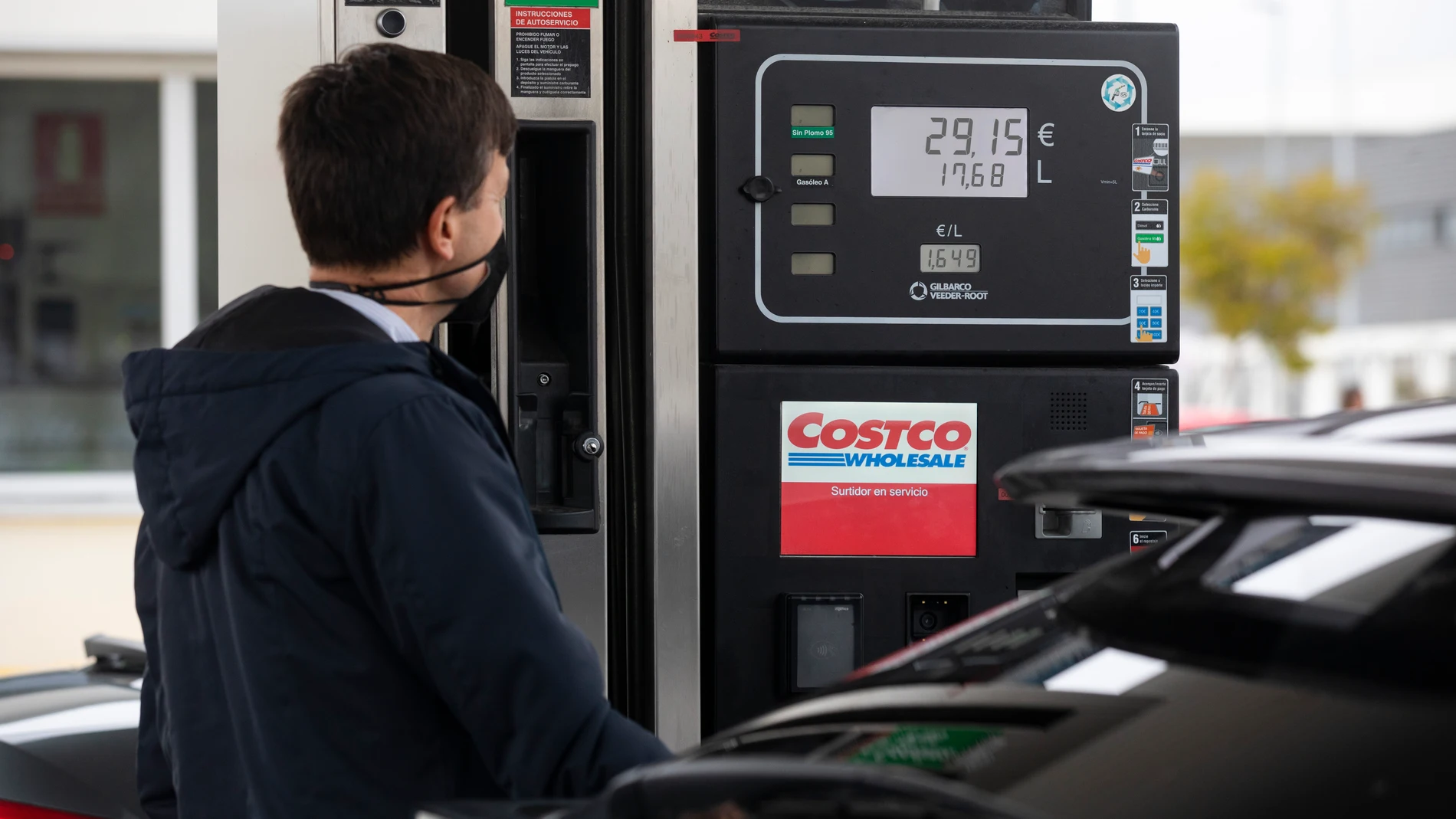 Un hombre repostando en una gasolinera en Getafe en la que numerosos coches hacen cola ante la subida de precios del combustible | Fuente: Jesús G.Feria