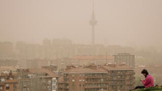 Una mujer observa la calima y la lluvia desde el mirador del Cerro del T&iacute;o P&iacute;o, Madrid