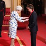 Isabel II condecorando a Paul McCartney, en 1997