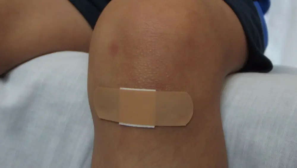 Niño con una herida en la rodilla