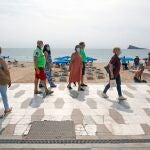 Miembros de una asociación de mayores de Madrid pasean por una playa levantina