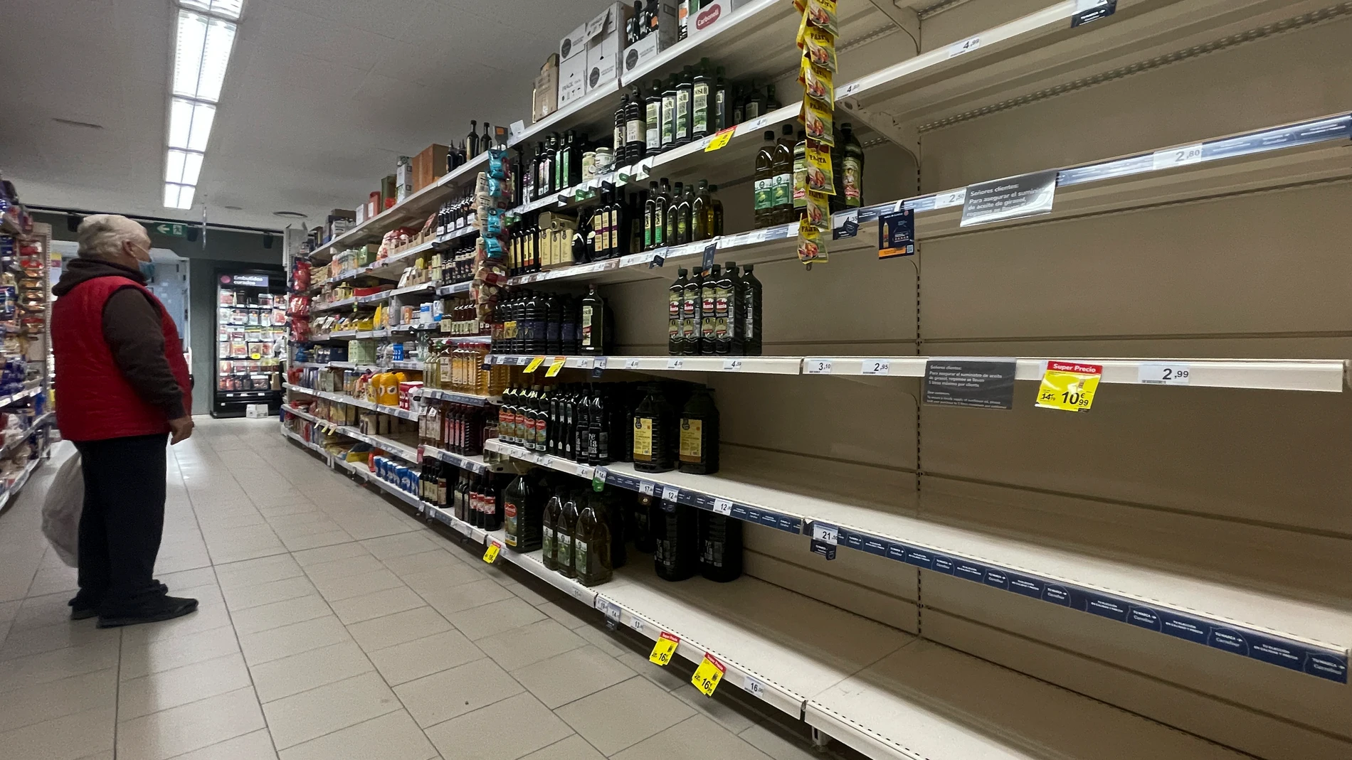 MADRID, 19/03/2022.- Un hombre observa unas estanterías vacías de aceite en un supermercado de Madrid este sábado. Los supermercados y grandes superficies comienzan ya a sufrir las consecuencias de la huelga de transportistas, con desabastecimiento de productos esenciales como arroz, pasta, aceite, vacuno, pescado y harinas, mientras que comercios locales y mercados de proximidad resisten la embestida. EFE/Sergio Pérez