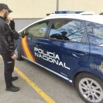 Un agente de la Policía Nacional, junto a un vehículo policial