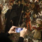 Una visitante fotografía la obra «Cortejo del bautizo del príncipe Don Juan»