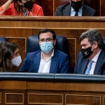 La ministra de Igualdad, Irene Montero; el ministro de Consumo, Alberto Garzón; y el ministro de Inclusión, Seguridad Social y Migraciones, José Luis Escrivá, conversan una sesión plenaria