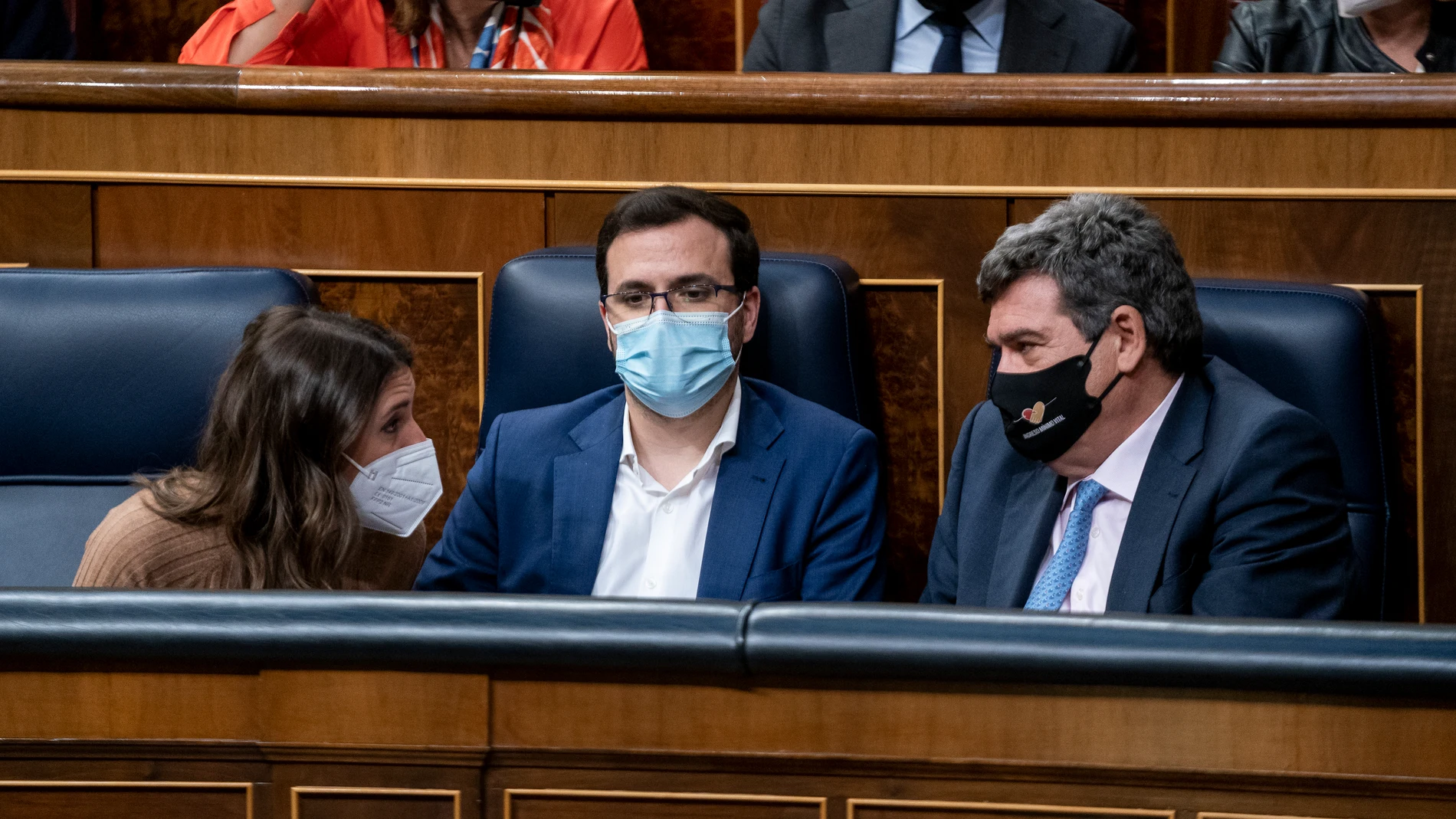 La ministra de Igualdad, Irene Montero; el ministro de Consumo, Alberto Garzón; y el ministro de Inclusión, Seguridad Social y Migraciones, José Luis Escrivá, conversan una sesión plenaria