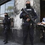 Policías fuertemente armados vigilan las calles del centro de San Salvador, El Salvador, el domingo 27 de marzo de 2022.