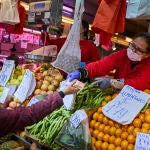 Gente comprando en un establecimiento de frutería