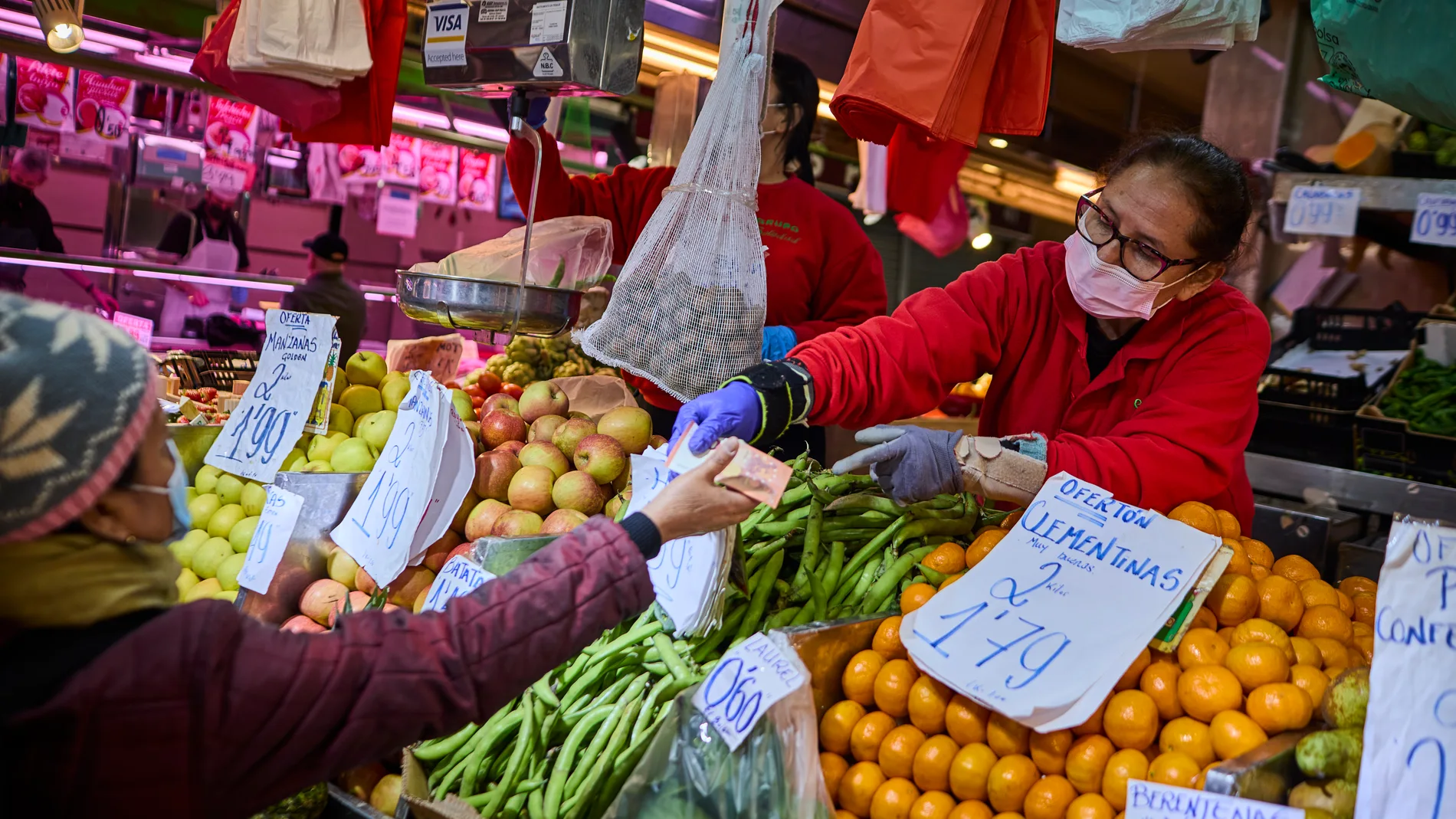 Gente comprando en un establecimiento de frutería