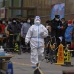 Varias personas esperan un una fila para realizarse un test de coronavirus tras detectarse un caso en un edificio residencial de Beijing
