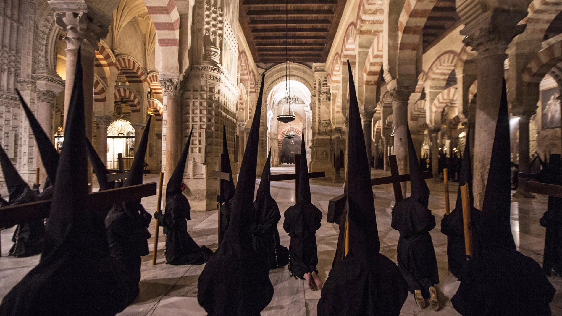 Devotos de la "Hermandad del Vía Crucis" procesionando dentro de la Mezquita-Catedral de Córdoba