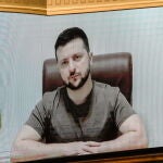El presidente ucraniano Volodimir Zelenski en la pantalla del Parlamento finlandés hoy dirigiéndose a sus señorías