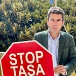 El presidente del PPCV, Carlos Mazón, con un cartel de la campaña 'Stop a la tasa turística'