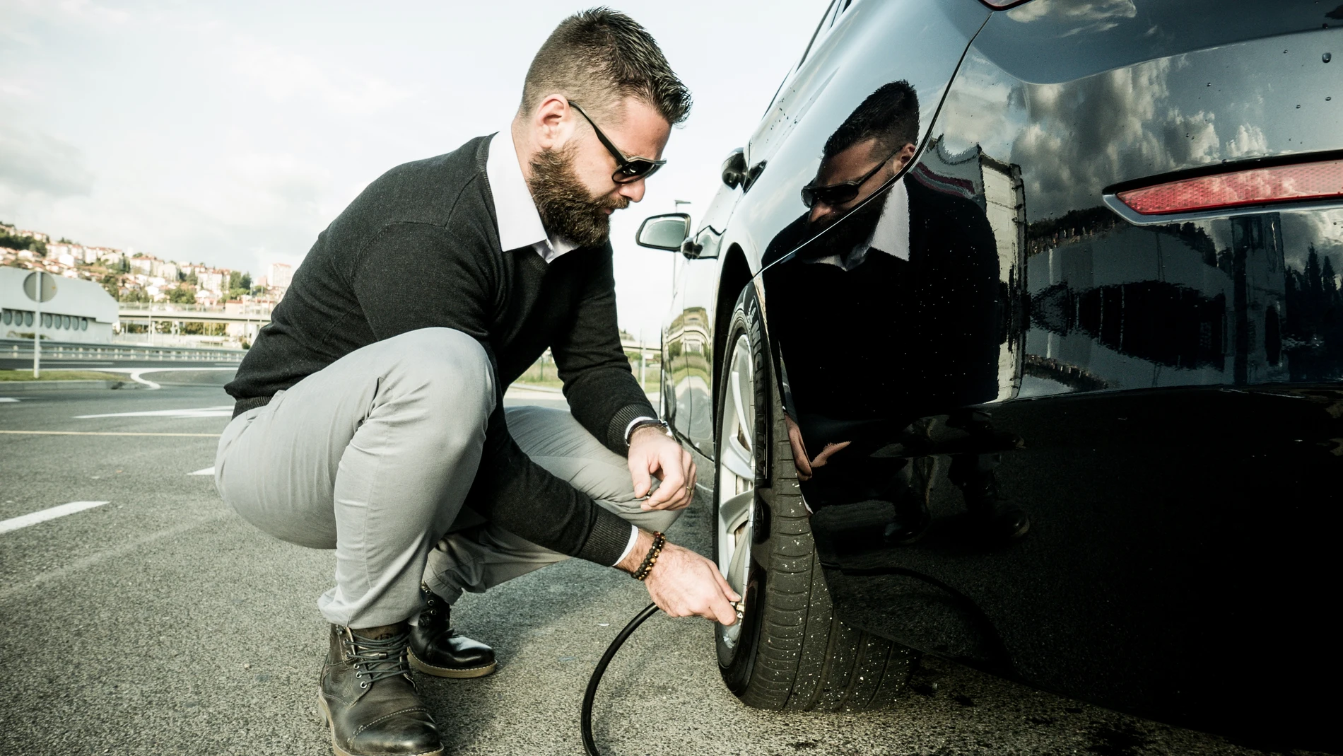 Hombre comprobando la presión de los neumáticos