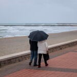 Una parejase protege de la lluvia con un paraguas