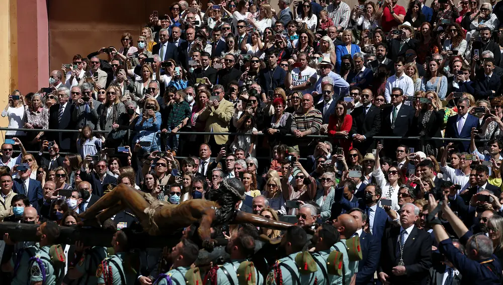 Una multitud asiste al traslado del Cristo de la Buena Muerte y Ánimas, por parte de legionarios del Tercio Gran Capitán, a la casa hermandad de la Cofradía de Mena este Jueves Santo en Málaga. EFE/Daniel Pérez