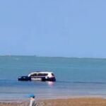 El coche policial dentro del mar, tras subir la marea