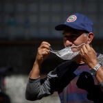 Una persona se pone una mascarilla