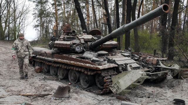 Un soldado ucraniano pasa junto a un carro de combate ruso destruido por los combates en Moshchun, cerca de Kiev