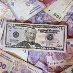 AME2498. BUENOS AIRES (ARGENTINA), 20/04/2022.- Fotografía de billetes de dolares, el 19 de abril de 2022, en Buenos Aires (Argentina). La aceleración de la inflación en Argentina, un problema endémico del país, ha avivado entre los expertos y algunos sectores políticos el debate sobre un eventual reemplazo del peso por el dólar, en una economía ya considerada bimonetaria por el histórico uso que los argentinos hacen del dólar para ahorrar y como refugio ante la siempre devaluada divisa local. EFE/ Juan Ignacio Roncoroni
