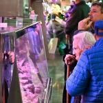 Un par de clientes sin mascarilla aguardan a ser atendidos un mercado de Madrid