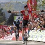 Dylan Teuns levanta los brazos al entrar vencedor en meta con Alejandro Valverde al fondo