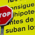 Cartel publicitario de Idealista que reza "consigue tu hipoteca antes de que suban los tipos" junto a una señal de Stop