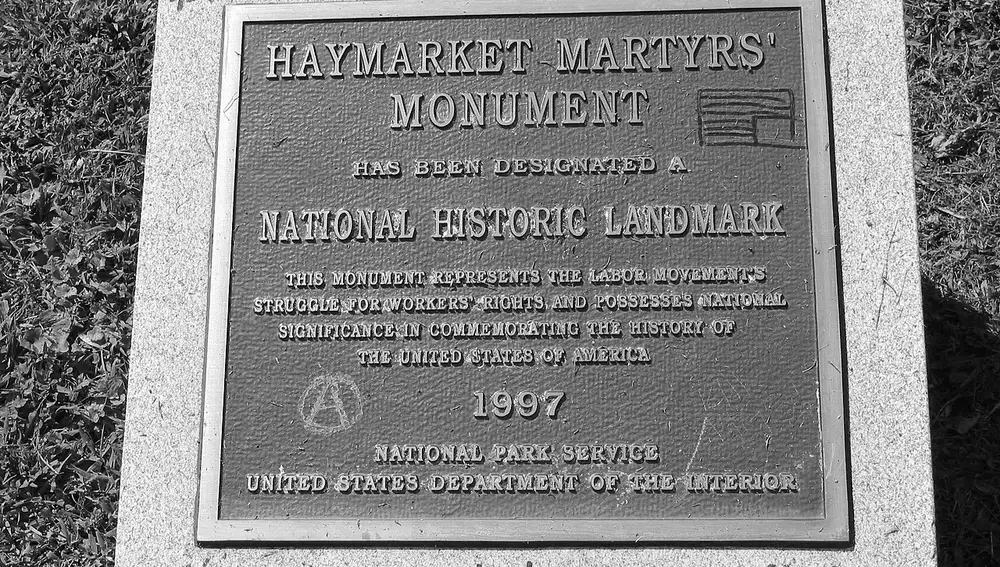 Placa conmemorativa dedicada a "los mártires de Haymarket" en el que alguien escribió con rotulador: "Primero tomaron vuestras vidas, ahora explotan vuestra memoria" | Dominio Público