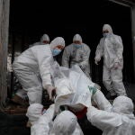 Soldados ucranianos descargan bolsas con cadáveres de soldados rusos antes de llevarlos a un vagón frigorífico en una estación de ferrocarril de Kyiv