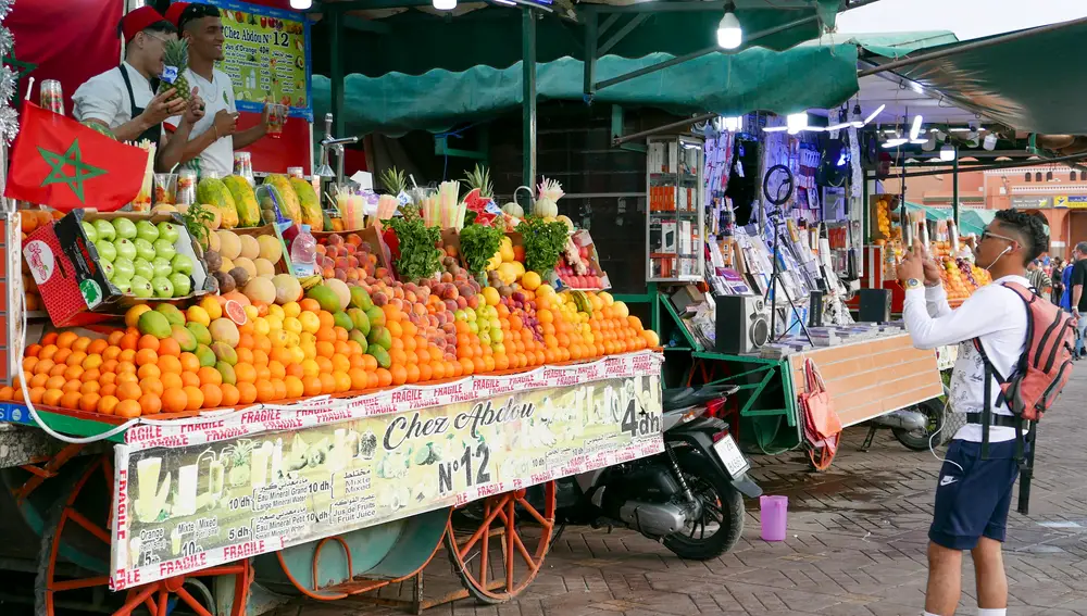 Dos vendedores de fruta posan para una foto en un mercado de Marrakech (Marruecos)