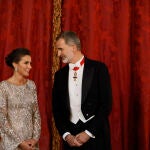 El rey Felipe VI conversa con la reina Letizia (i) a su llegada a la cena de gala ofrecida al emir de Catar, Tamim bin Hamad Al Thani, y su esposa este martes en el Palacio Real, en Madrid.