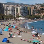 Numerosas personas disfrutan de un día de playa en La Malagueta de la capital malagueña. EFE/Daniel Pérez