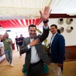 El presidente de la Junta de Andalucía , Juanma Moreno, saluda en una caseta de la Feria de Mayo de Córdoba. EFE / Rafa Alcaide