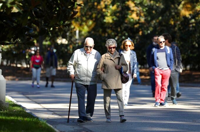 Pensionistas paseando por un parque.