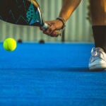 A young paddle tennis player catching the ball with the racket - Sportsman playing padel game