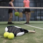 Paddle tennis objects on turf ready for tournament and women in background
